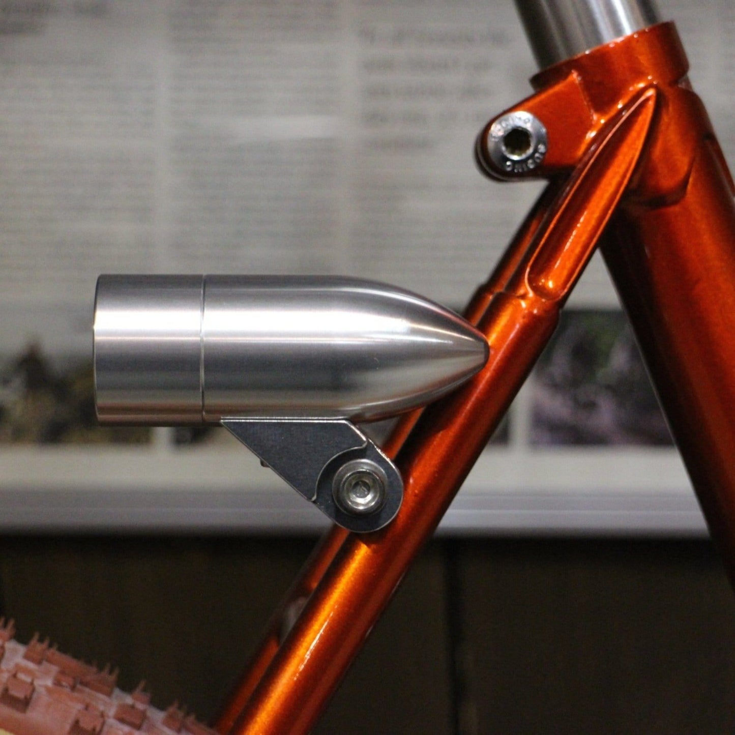 Silver Rindow bullet rear bicycle light mounted on an orange bike with the universal mount